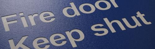 Machine à graver par fraisage en plastique bleu avec texte d'avertissement blanc sur la porte coupe-feu