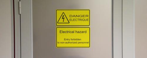 Signétique de sécurité gravée au laser en Gravoply™ Laser sur une porte industrielle pour la sécurité au travail.